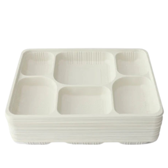 Stack of white cornstarch divided serving trays on a white background