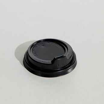 Black coffee cup lid on a light gray background