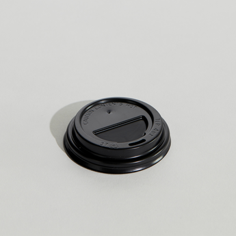 Black coffee cup lid on a light gray background