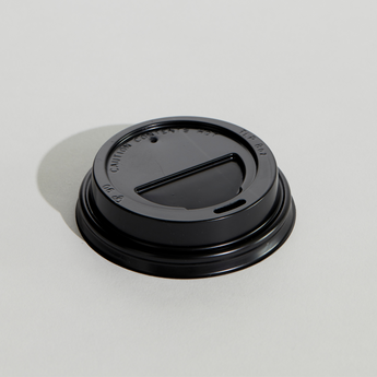 Black coffee cup lid on a light gray background