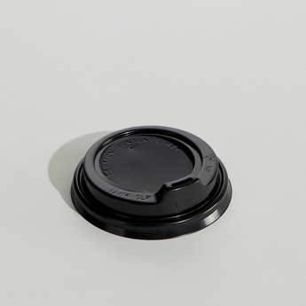 Black coffee cup lid on a light gray background