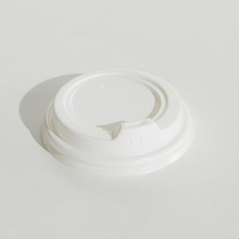 White coffee cup lid on a light gray background