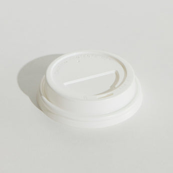White disposable coffee cup lid on a light gray background