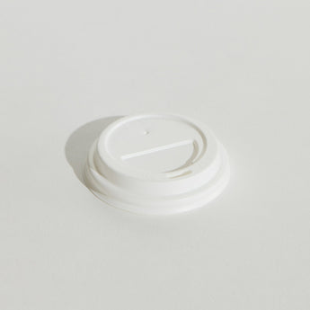 White disposable coffee cup lid on a light gray background