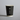 Black paper cup with a beige rim on a gray background